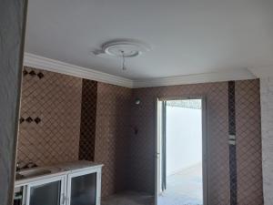 a kitchen with a ceiling fan and a room with a window at soussoleil in Bin Rhilouf