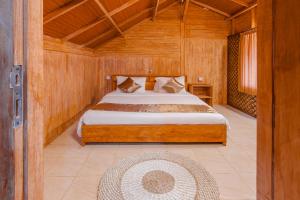 une chambre avec un lit dans une pièce en bois dans l'établissement Kampung Bingo Glamping & Resto by Great Bali Villas, à Bedugul