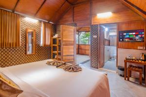 a bedroom with a large white bed in a room at Kampung Bingo Glamping & Resto by Great Bali Villas in Bedugul