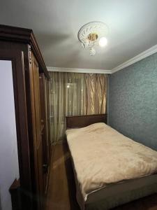a bedroom with a bed and a chandelier at flat in Itʼkhvisi