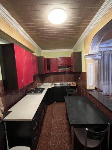 a kitchen with red cabinets and a black counter top at flat in Itʼkhvisi