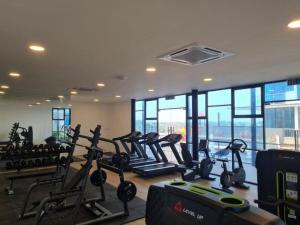 Un gimnasio con cintas de correr y elípticas en una habitación con ventanas. en Hann's Residence 2 - Anna 温馨公寓式的住宅, en Sibu