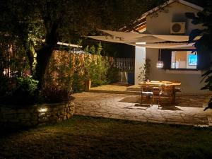 a table and chairs in front of a house at night at La casa di Kapo in Syvota