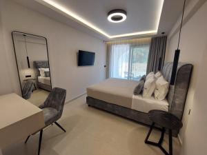 Un dormitorio con una cama, un escritorio y un espejo. en Avra Suites, en Kerion