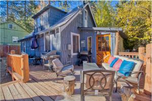 a large deck with a couch and a house at Ray's Dear Cottage- A relaxing place in the woods in Wrightwood