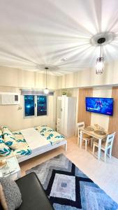 a bedroom with a bed and a table and a refrigerator at SUNVIDA TOWER, across SM City Cebu in Mandaue City