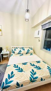 a bedroom with a bed with blue flowers on it at SUNVIDA TOWER, across SM City Cebu in Mandaue City +7 photos
