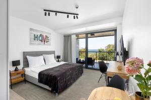 ein Hotelzimmer mit einem Bett und einem Schreibtisch mit einem Schreibtisch in der Unterkunft Seaside Park by Solarento in Kołobrzeg