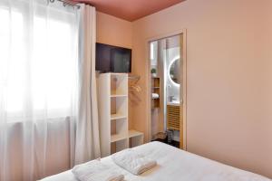 a bedroom with a bed and a window and a tv at Le Chic & Raffiné - Terrasse & Climatisé in Périgueux