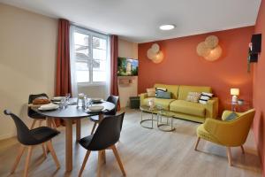 a living room with a table and chairs and a couch at Le Chic & Raffiné - Terrasse & Climatisé in Périgueux