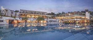 a hotel with a pool in front of a building at DoubleTree by Hilton Bodrum Isil Club Ultra All-Inclusive Resort in Torba