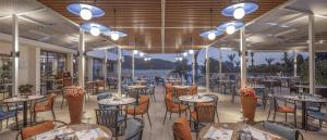 a restaurant with tables and chairs and lights at DoubleTree by Hilton Bodrum Isil Club Ultra All-Inclusive Resort in Torba