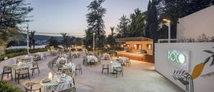 a restaurant with tables and chairs on a patio at DoubleTree by Hilton Bodrum Isil Club Ultra All-Inclusive Resort in Torba
