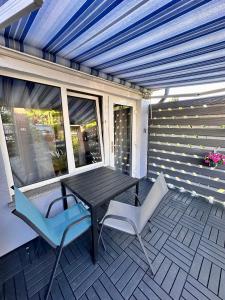 a patio with a table and two chairs on a porch at Ost See Blick Ferienwohnung Nr1 Baabe in Baabe