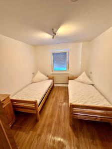 two beds in a room with a window at Ost See Blick Ferienwohnung Nr1 Baabe in Baabe