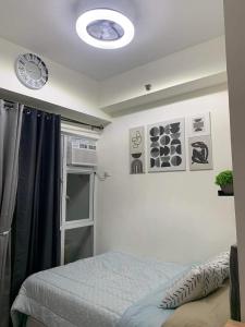 a bedroom with a bed and a clock on the ceiling at EK's Place in Manila
