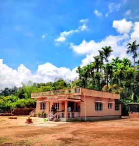 a house with a balcony on top of it at Nelligudda Homestay in Kalasa