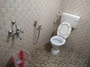 a bathroom with a toilet in a stall at Nelligudda Homestay in Kalasa