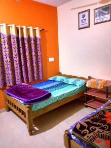 a bedroom with a bed with colorful walls and curtains at Nelligudda Homestay in Kalasa