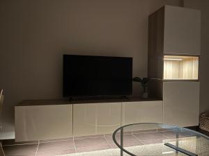 a flat screen tv sitting on top of a white cabinet at Apartamento Son do Mar in Porto do Son