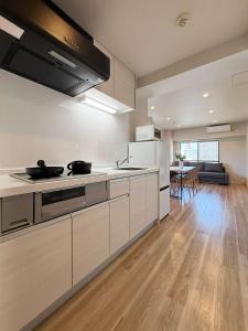 a kitchen with white appliances and a dining room at Grandeur - Family-Sized Apt Near Peace Park with River View in Hiroshima