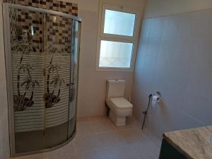 a bathroom with a shower and a toilet and a window at Baraka in Aghīr +22 photos