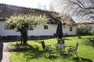 a table and chairs and an umbrella in front of a house at B&B Hannåsa Gård in Hammenhög