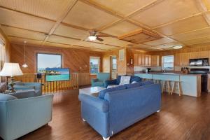 a living room with two blue couches and a kitchen at 7143 - Geri's Place #4 in Wanchese