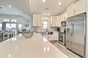 une cuisine avec des armoires blanches et un réfrigérateur en acier inoxydable dans l'établissement 5201 - Mint Julep, à Croatan Shores