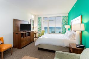 a hotel room with a bed and a large window at Holiday Inn Resort Fort Walton Beach by IHG in Fort Walton Beach