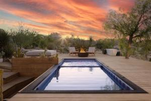 ユッカ・バレーにあるBoulder Horizons - PoolSpaCold Plunge on 5 acresの夕日が沈むパティオの真ん中にあるプール
