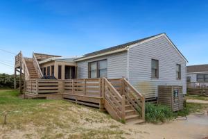 a house with a wooden deck on the beach at 7145 - Geri's Place #6 Flip Flop in Wanchese