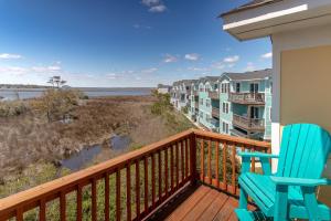 a balcony with two chairs and a view of the ocean at CP100A - Sound Sunset in Kill Devil Hills