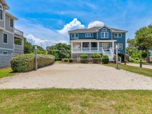 a blue house with a volleyball court in front of a house at 2072 - Laughing Duck in Duck