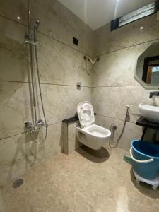 a bathroom with a shower and a toilet and a sink at Hotel Village Villa in Indore +8 photos