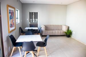 a living room with tables and chairs and a couch at Glowti Event & Guest House in Centurion