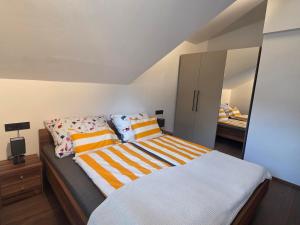 a bedroom with a bed with striped pillows and a mirror at Resi's Kitz Lodge in Kitzbühel