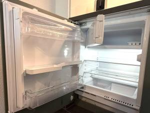 un réfrigérateur vide avec sa porte ouverte dans une cuisine dans l'établissement Royal 41, à Loèche-les-Bains