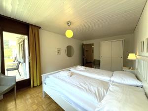een groot wit bed in een kamer met een raam bij Royal 41 in Leukerbad +23 foto's