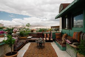 eine Terrasse mit Sofas und einem Tisch auf einem Balkon in der Unterkunft Heybe Hotel & Spa in Goreme