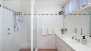 Un baño blanco con ducha y lavabo. en Shoal Bay Townhouse with Spa, en Shoal Bay 20 fotos más