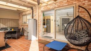 Habitación con una gran puerta de cristal con un columpio en Shoal Bay Townhouse with Spa, en Shoal Bay