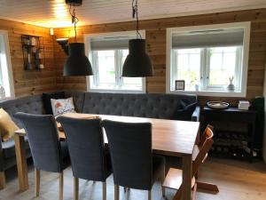 a dining room with a wooden table and chairs at Familiehytte på Kvamskogen in Kvam