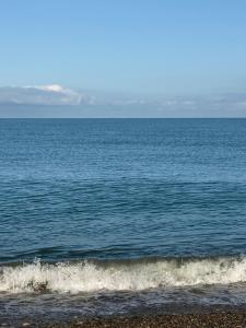 a large body of water with a beach and waves at Mzeonas Apartment in K'obulet'i