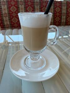 a glass cup of coffee on a plate on a table at Mzeonas Apartment in K'obulet'i