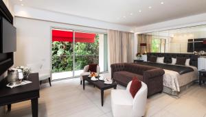 a bedroom with a bed and a living room at Forte Village Resort - Villa Del Parco & Spa in Santa Margherita di Pula +15 photos