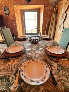 a table with plates and utensils on it at U Magazinu in Pino
