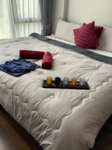 a bed with a tray with three candles on it at Superb Apartment! 5 Mins to the Beach in Ban Lum Fuang +28 photos