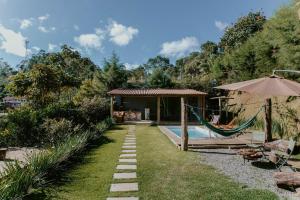 einen Garten mit Hängematte und ein Haus in der Unterkunft Luxo e Aconchego na Natureza - DM in Domingos Martins
