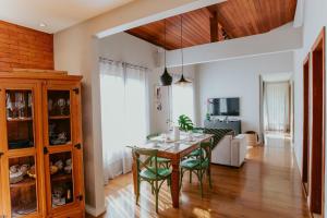 ein Esszimmer und ein Wohnzimmer mit Tisch und Stühlen in der Unterkunft Luxo e Aconchego na Natureza - DM in Domingos Martins